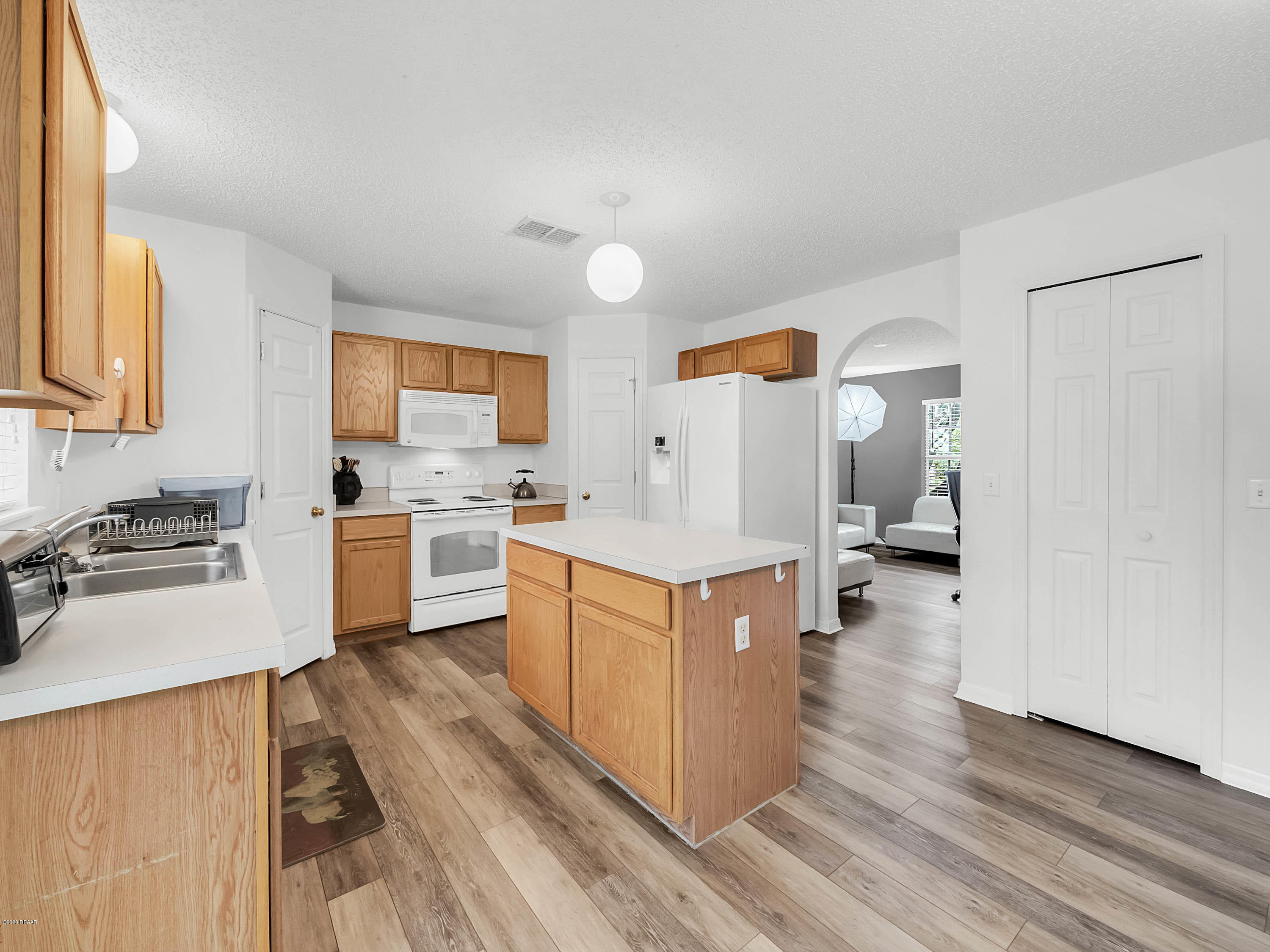 1982 7th Avenue DeLand, FL 32724 - Photo 10 of 36 a large kitchen with stainless steel appliances a stove a sink dishwasher and a refrigerator with wooden floor