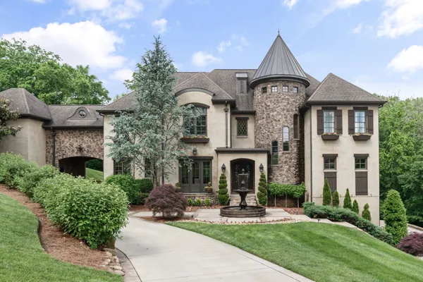a front view of a house with yard and parking