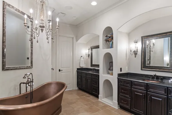 a bedroom with a large bed and a chandelier