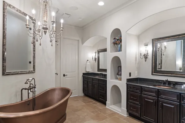a bedroom with a large bed and a chandelier
