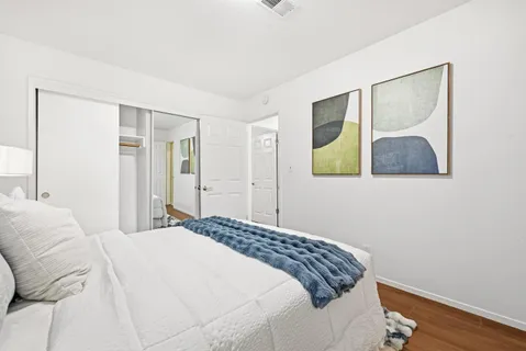 a bedroom with a bed and a painting on the wall