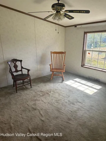 a view of an empty room with a window and furniture