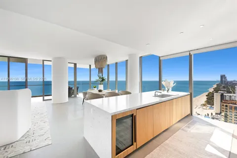 a large kitchen with stainless steel appliances a large counter top a stove and a wooden floors