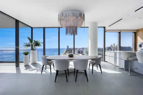 a living room with kitchen island granite countertop furniture a rug and a large window