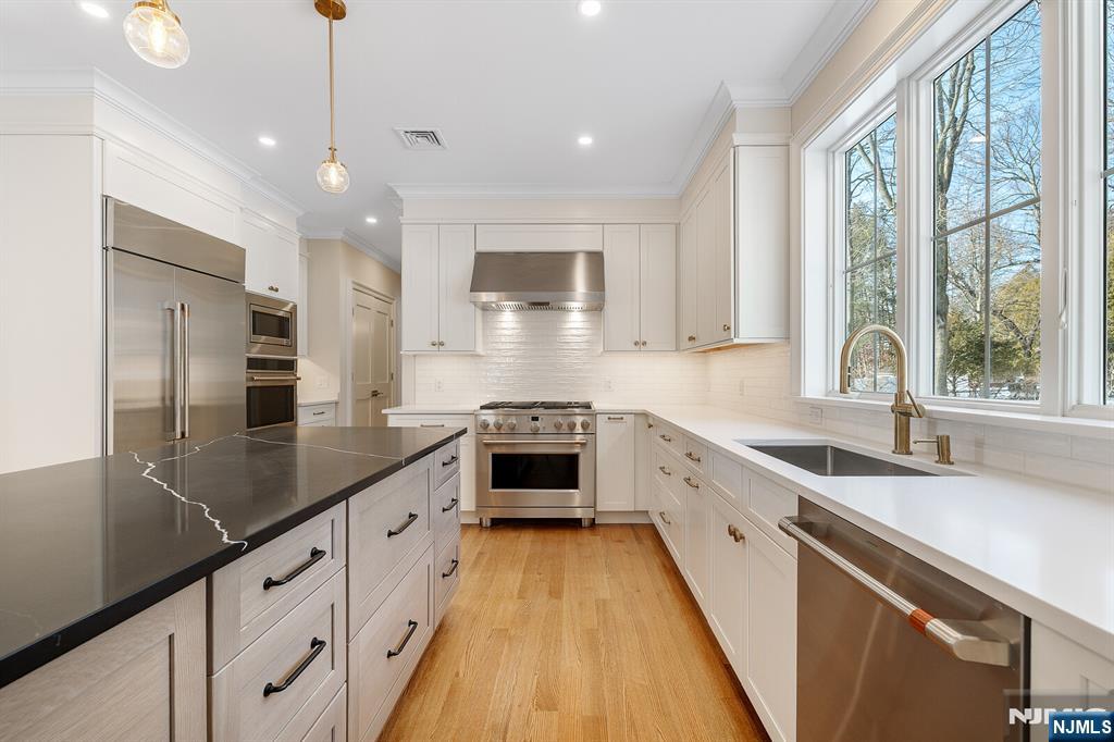 62 Colony Avenue Park Ridge, NJ 07656 - Photo 12 of 50 a large kitchen with stainless steel appliances kitchen island a large counter top a sink a stove and a refrigerator