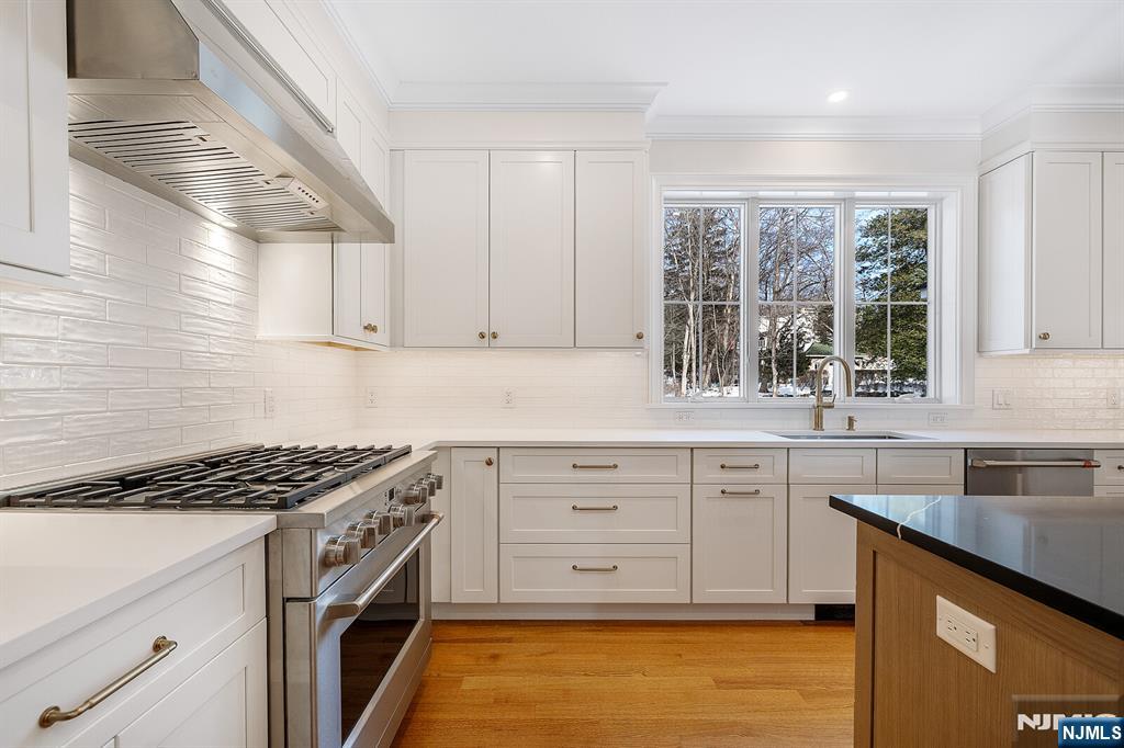 62 Colony Avenue Park Ridge, NJ 07656 - Photo 13 of 50 a kitchen with granite countertop a white stove top oven sink and cabinets