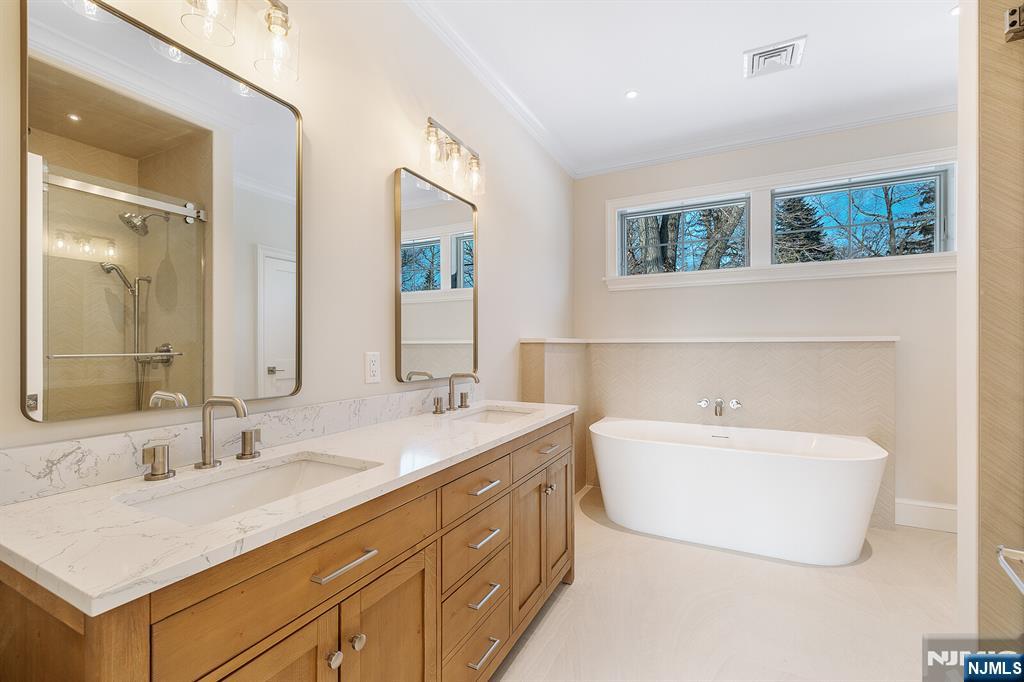 62 Colony Avenue Park Ridge, NJ 07656 - Photo 31 of 50 a bathroom with a double vanity sink mirror and bathtub