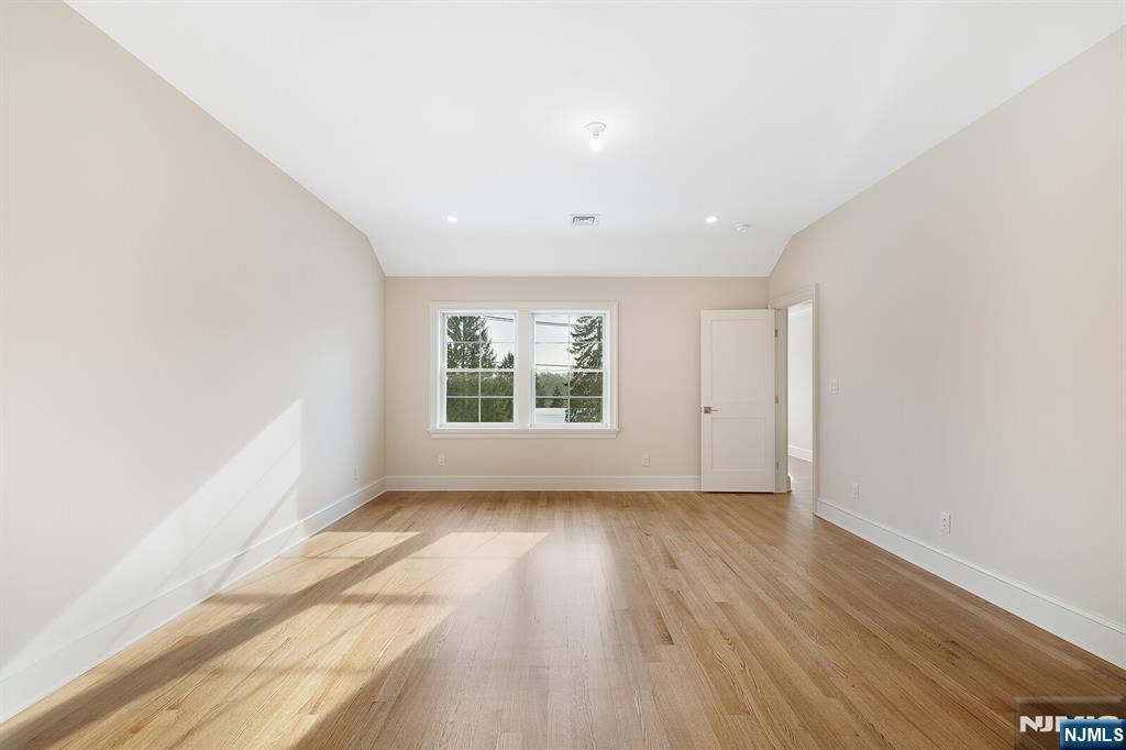 62 Colony Avenue Park Ridge, NJ 07656 - Photo 35 of 50 an empty room with wooden floor and windows