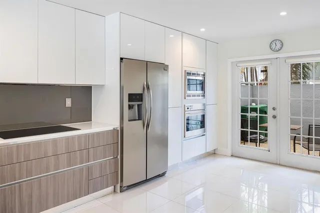 a view of a kitchen with refrigerator and more cabinets