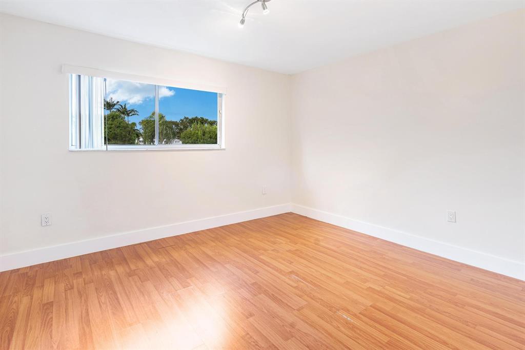 9703 Southwest 142nd Court Miami, FL 33186 - Photo 16 of 36 a view of an empty room with wooden floor and a window