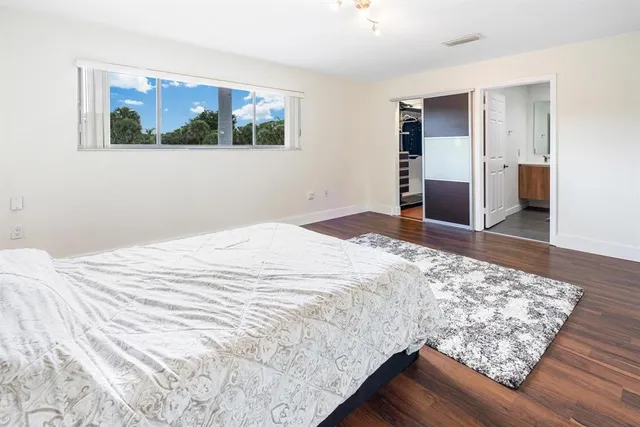 a bedroom with a bed and a painting on the wall