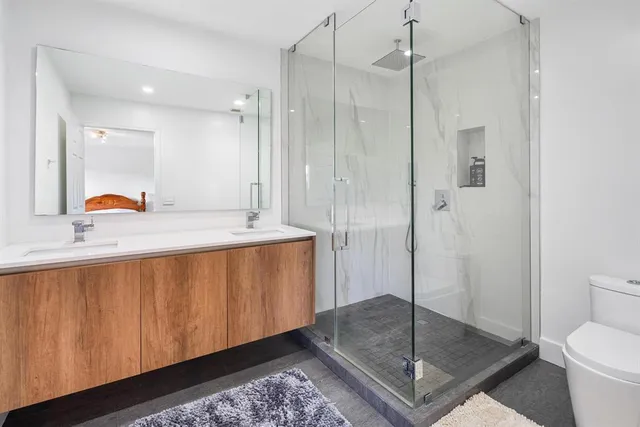 a bathroom with a sink a toilet and shower