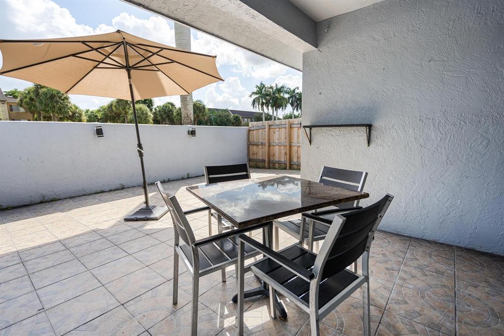 9703 Southwest 142nd Court Miami, FL 33186 - Photo 28 of 36 a backyard of a house with table and chairs