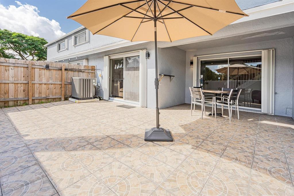 9703 Southwest 142nd Court Miami, FL 33186 - Photo 29 of 36 a backyard of a house with table and chairs