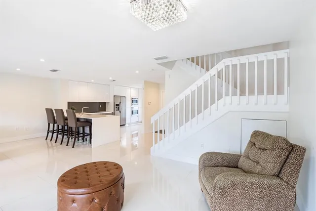 a living room with furniture a dining table and a chandelier