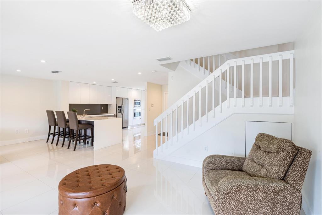 9703 Southwest 142nd Court Miami, FL 33186 - Photo 4 of 36 a living room with furniture a dining table and a chandelier