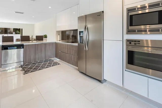 a kitchen with stainless steel appliances granite countertop a refrigerator and a stove top oven