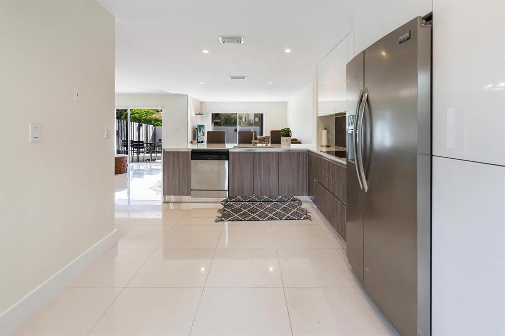 9703 Southwest 142nd Court Miami, FL 33186 - Photo 10 of 36 a kitchen with stainless steel appliances kitchen island granite countertop a refrigerator a stove and a sink with large countertops