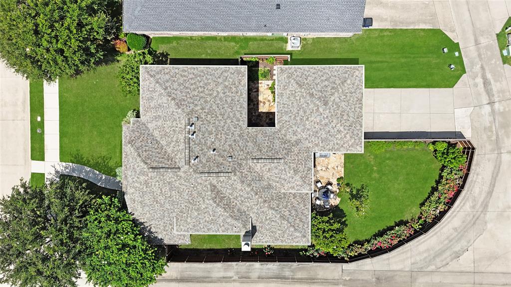 960 Remuda Road Frisco, TX 75033 - Photo 34 of 39 Overhead view of a residential property featuring a shingle roof, paved driveway, concrete walkways, green lawn, and mature trees