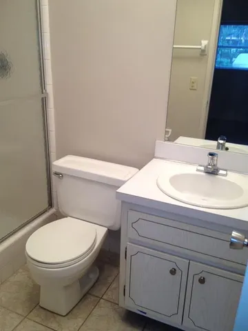 a bathroom with a toilet a sink and mirror