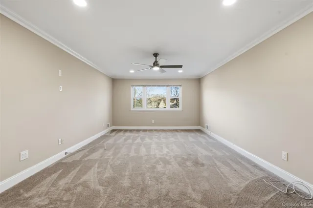 an empty room with windows and a ceiling fan