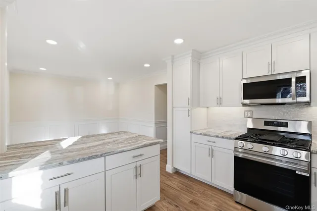 a kitchen with granite countertop a sink appliances and cabinets