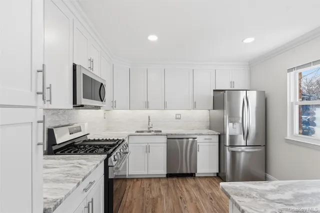 a kitchen with stainless steel appliances granite countertop a stove refrigerator sink and microwave