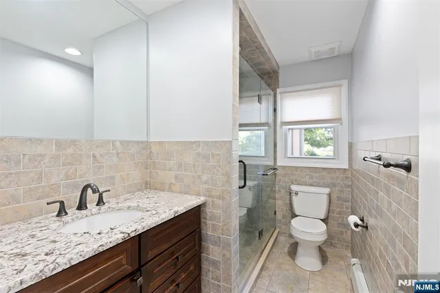 a bathroom with a granite countertop sink toilet and shower