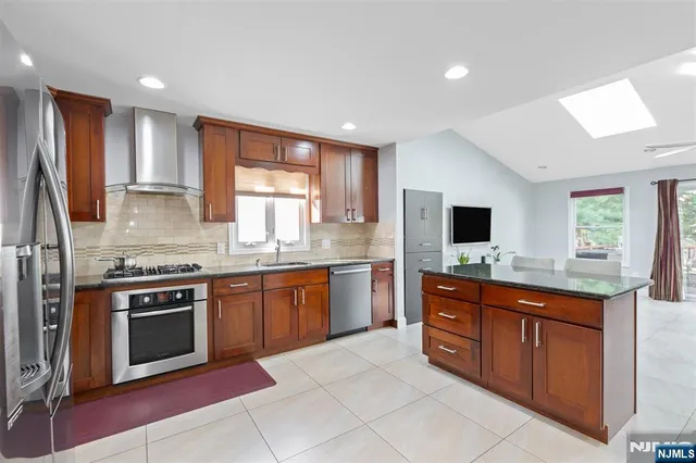 a kitchen with stainless steel appliances granite countertop a stove sink and microwave