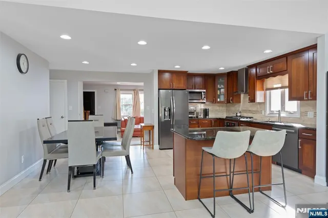 a kitchen with stainless steel appliances granite countertop a table and chairs