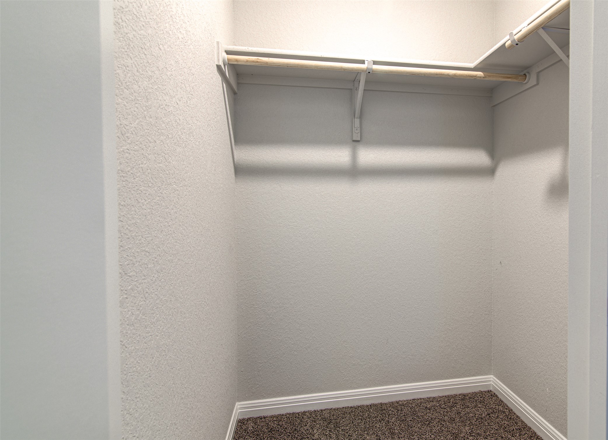 316 Pepper Mill Loop Burnet, TX 78611 - Photo 20 of 27 An organized walk-in closet with ample hanging space and neutral carpeting.