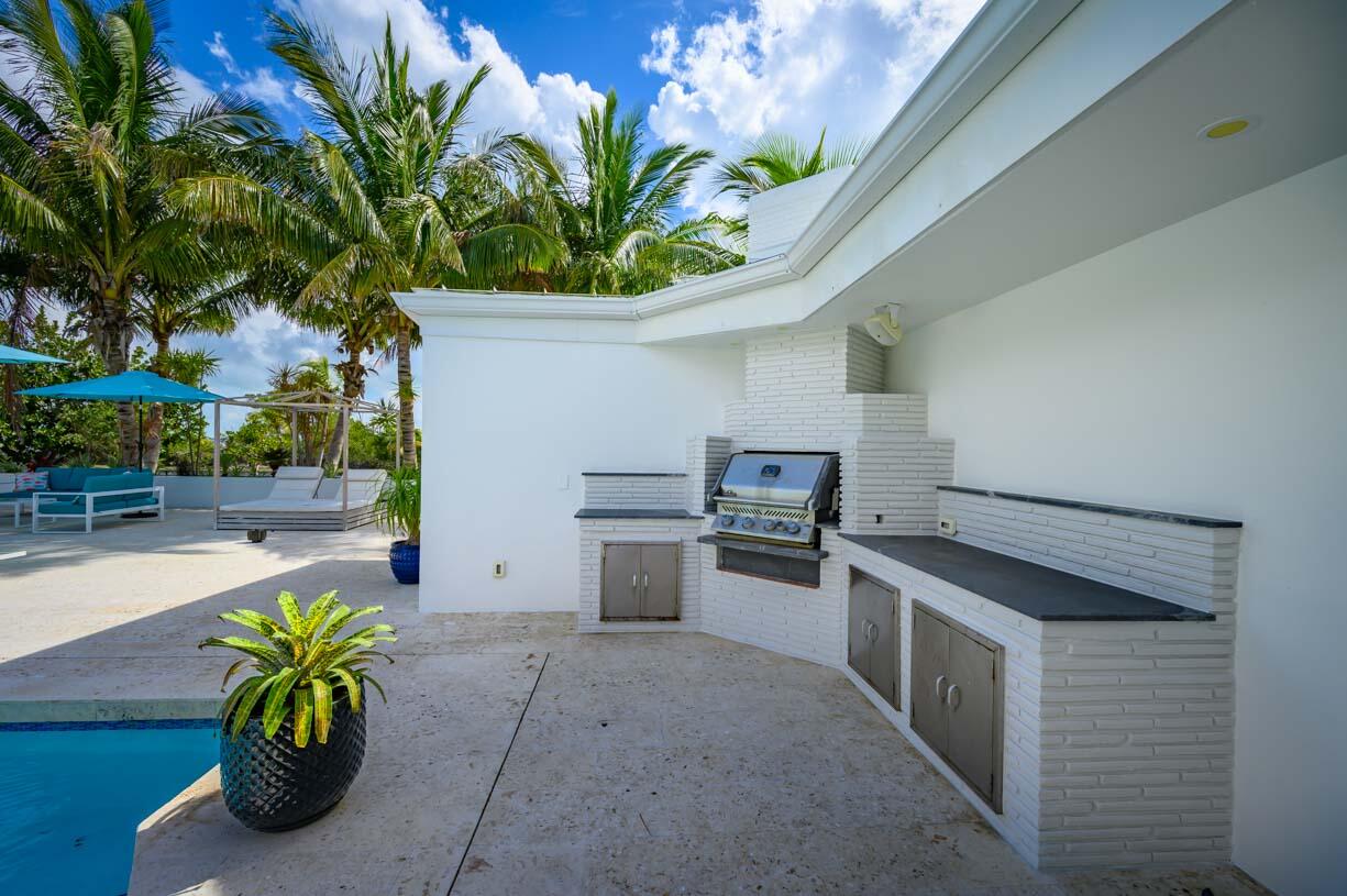 30680 Winifred Street Big Pine Key, FL 33043 - Photo 37 of 73 a white kitchen with a stove a sink and a potted plant
