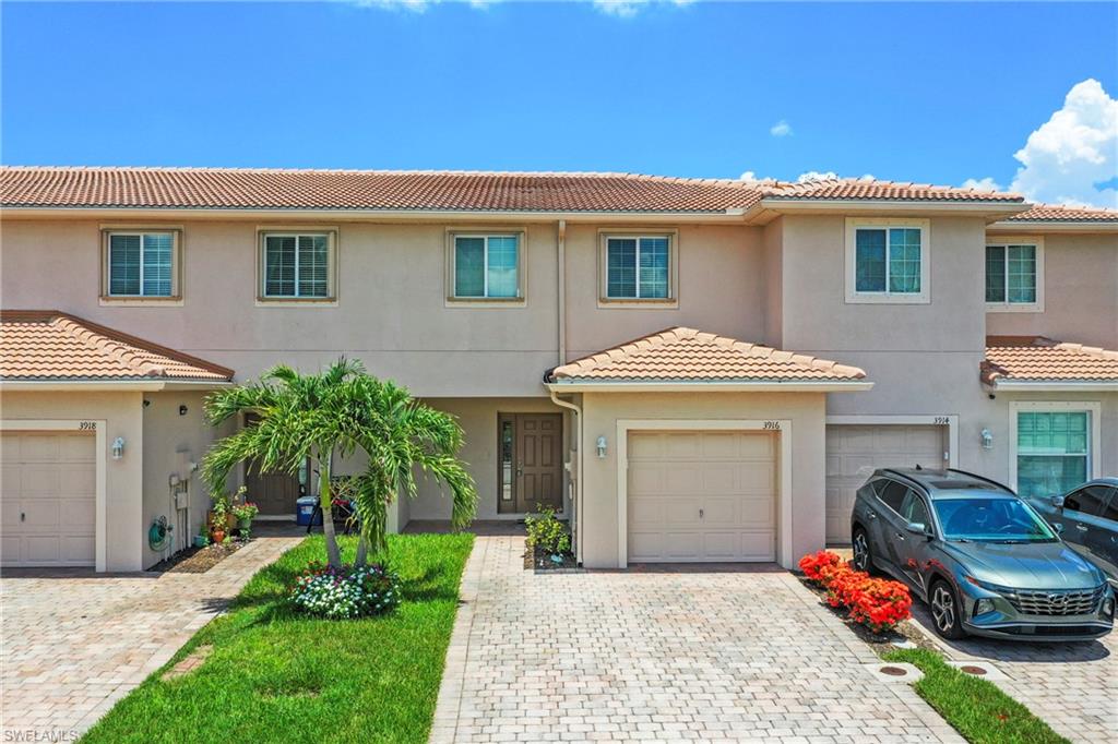 3916 Cherrybrook Loop Fort Myers, FL 33966 - Photo 2 of 31 Two-story townhome featuring a stucco exterior and a terracotta tile roof