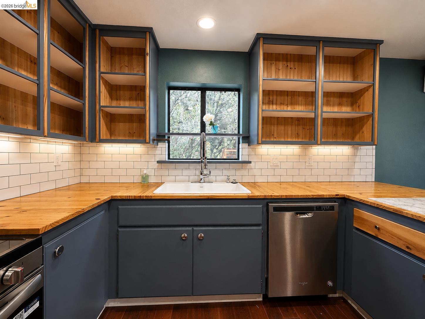 20663 Ferretti Road Groveland, CA 95321 - Photo 11 of 41 U-shaped kitchen featuring wood-finish countertops, subway tile backsplash, and blue-painted cabinetry