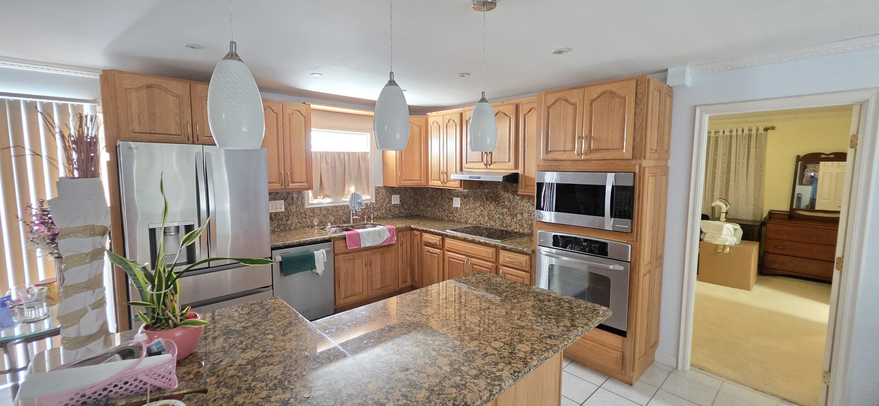 8 Emerald Drive Key West, FL 33040 - Photo 35 of 43 a kitchen with stainless steel appliances granite countertop a refrigerator a stove and white cabinets with wooden floor