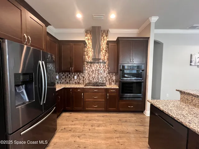 a kitchen with stainless steel appliances granite countertop a refrigerator and a stove