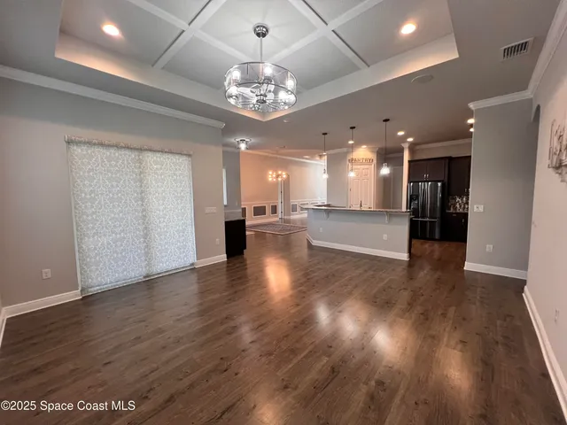 a view of a big room with wooden floor and a kitchen