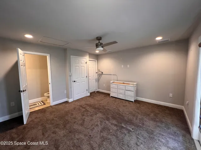 en empty room with windows and ceiling fan