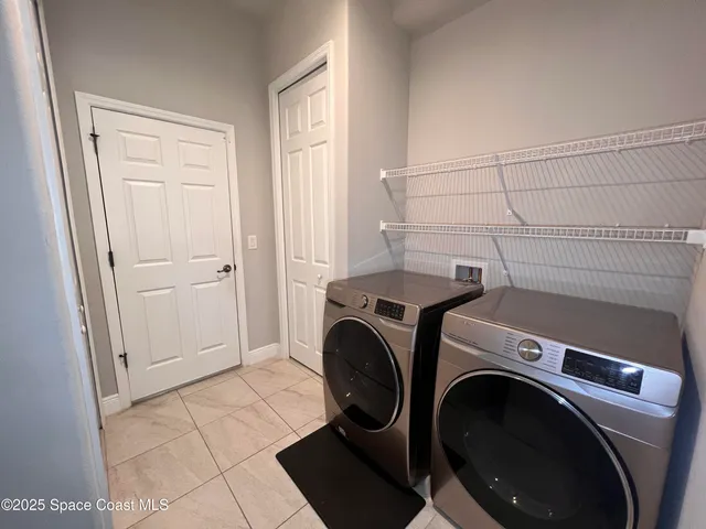 a view of a storage & utility room with dryer and washer
