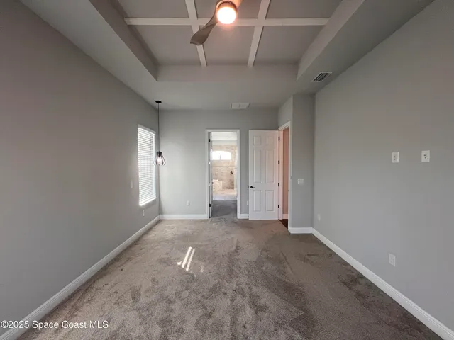 a view of a room with a ceiling fan and window
