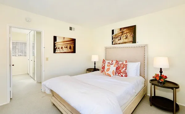 a bedroom with a bed and a painting on the wall