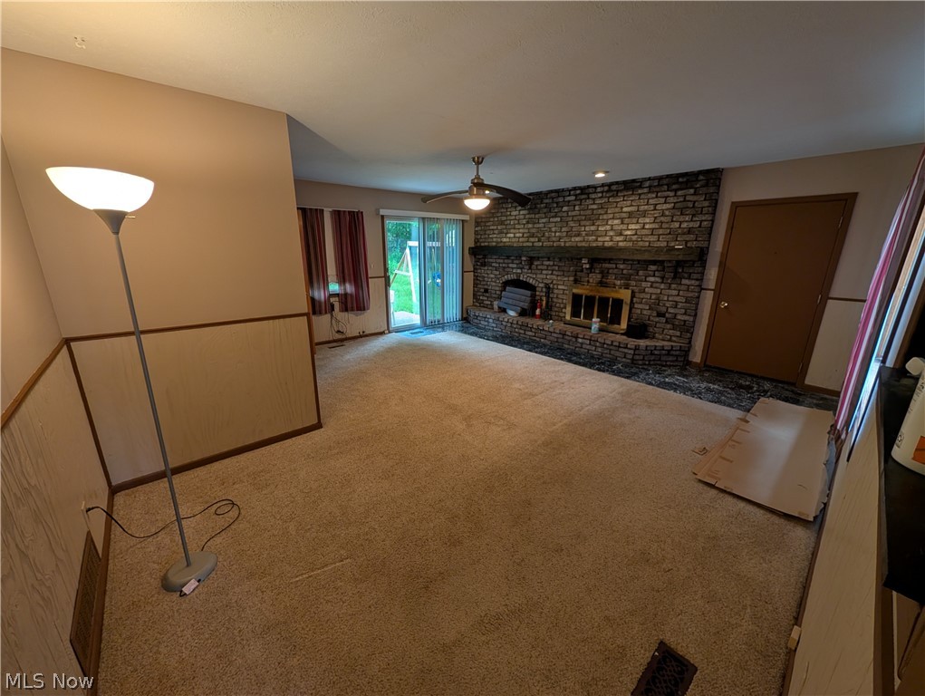5205 Blair Road Perry, OH 44081 - Photo 2 of 10 Living area featuring a brick fireplace with a wood mantle, ceiling fan, and carpet flooring