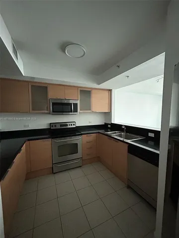 a large kitchen with stainless steel appliances granite countertop a stove and a sink