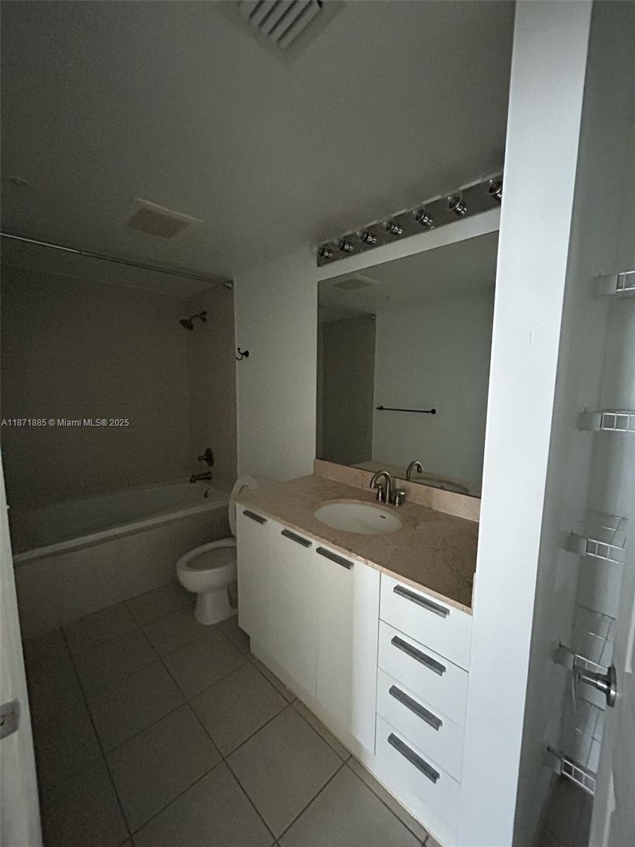 140 South Dixie Highway, Unit 816 Hollywood, FL 33020 - Photo 9 of 9 a bathroom with a granite countertop sink a toilet and a mirror