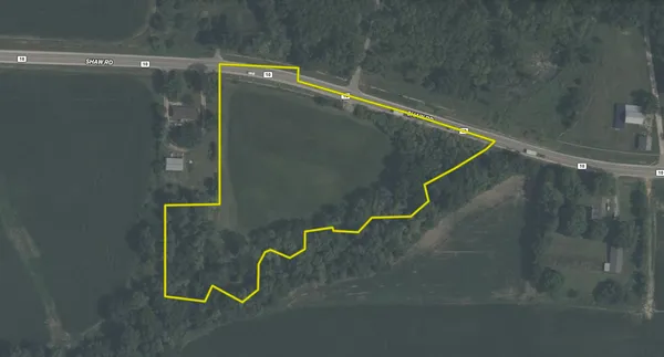 an aerial view of a residential houses with outdoor space and trees