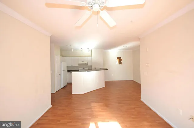 a view of a big room with wooden floor and windows