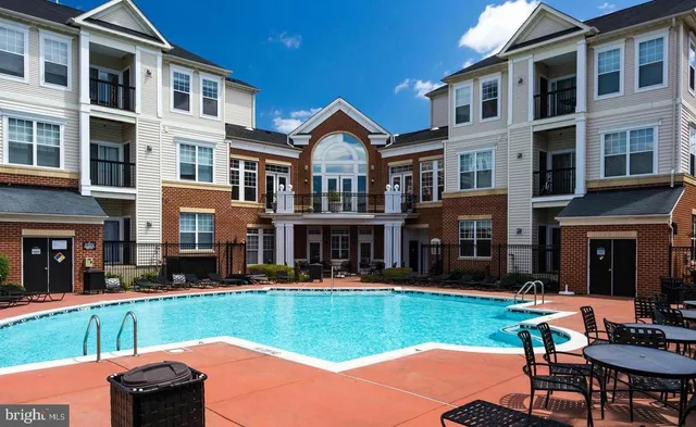 a front view of a house with swimming pool and chairs