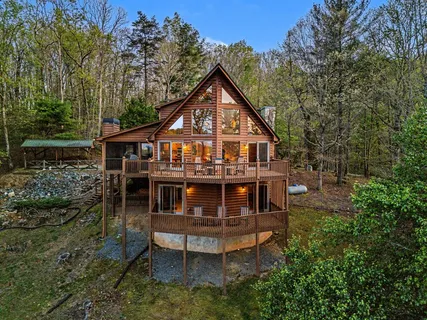 a view of house with a yard and deck