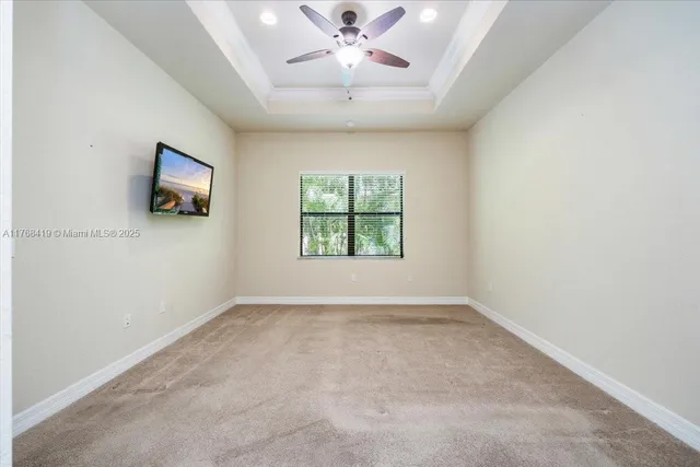 an empty room with windows and chandelier fan