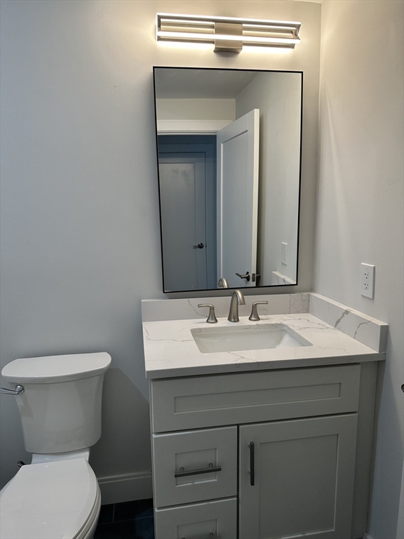 197 Condor Street, Unit 4 Boston, MA 02128 - Photo 13 of 14 a bathroom with a toilet sink and mirror